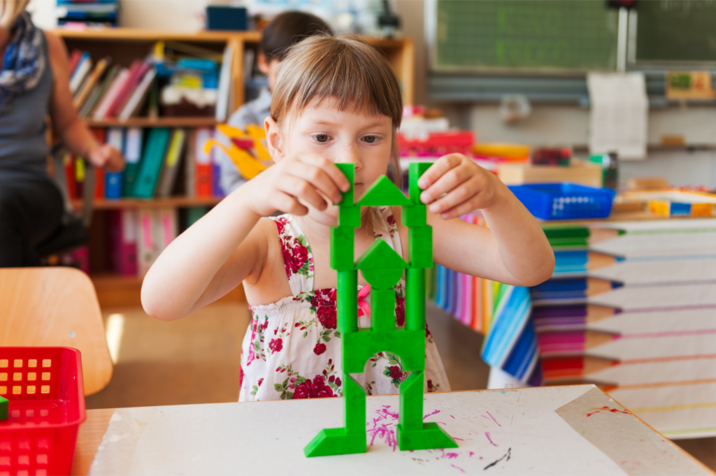 Une petite fille joue à un jeu de construction à l'école